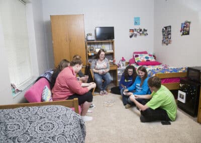 students playing cards on the floor in a residence hall