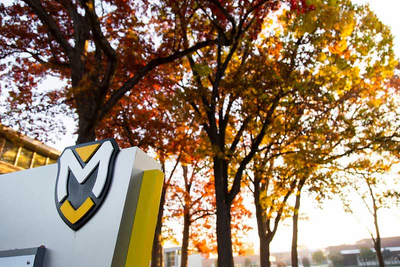 Manchester University signage with autumn trees