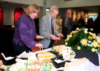 Man and woman taking food from a catering spread