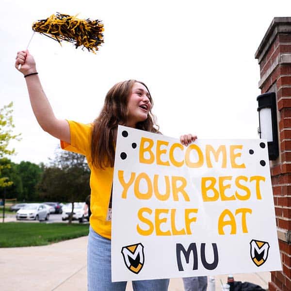 Be Your Best Self - student holds sign with a pom pom
